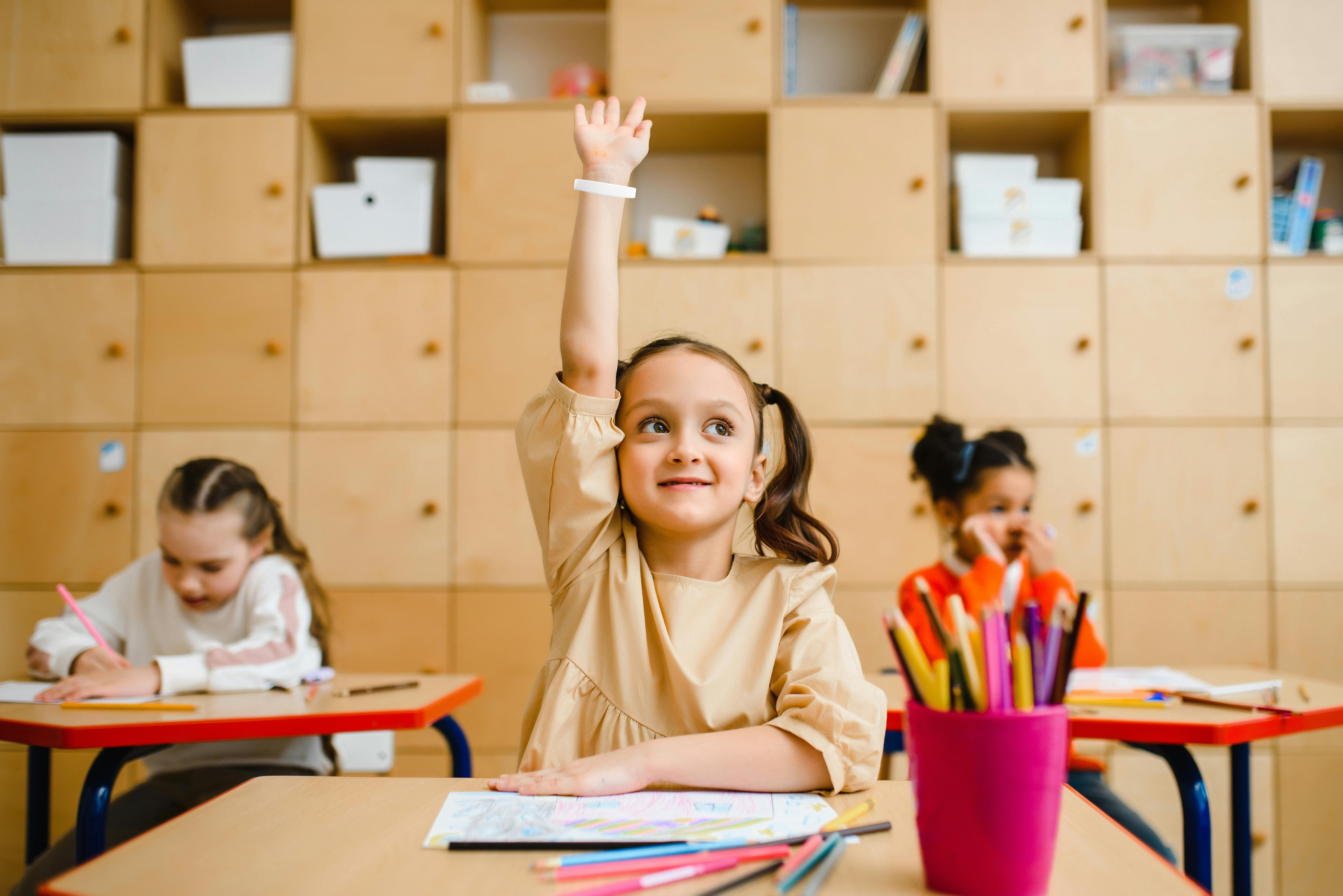 child raising their hand wearing a white wristband